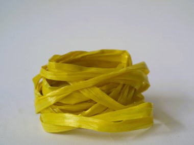 Beyaz arka planda izole edilmiş sarı bir rafya ipi rulosu. ev dekorasyonu yaratıcılık ekipmanı