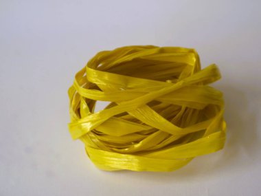 Beyaz arka planda izole edilmiş sarı bir rafya ipi rulosu. ev dekorasyonu yaratıcılık ekipmanı