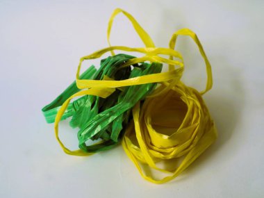 Beyaz arka planda izole edilmiş iki rulo yeşil ve sarı rafya ipi. ev dekorasyonu yaratıcılık ekipmanı