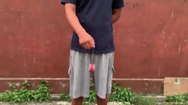 4K video, erkek eli yoyo oynuyor. Yoyo, iki diskten oluşan bir oyuncaktır, etrafında bir ip olan bir dingille bağlanır. Bir yoyo ipin üzerine atılır ve eline geri dönebilir.