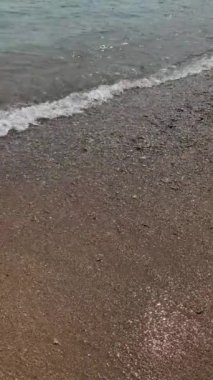 Sahildeki küçük dalgalar, kıyıdaki küçük dalgalar. Sakin ve sığ sularda hafif dalgalar dans etti. Yumuşak, mırıltılı dalgalar yatıştırıcı bir ninni yarattı. Kondang Merak Sahili, Malang, Doğu Java Endonezya