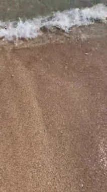 Sahildeki küçük dalgalar, kıyıdaki küçük dalgalar. Sakin ve sığ sularda hafif dalgalar dans etti. Yumuşak, mırıltılı dalgalar yatıştırıcı bir ninni yarattı. Kondang Merak Sahili, Malang, Doğu Java Endonezya