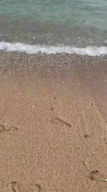 Sahildeki küçük dalgalar, kıyıdaki küçük dalgalar. Sakin ve sığ sularda hafif dalgalar dans etti. Yumuşak, mırıltılı dalgalar yatıştırıcı bir ninni yarattı. Kondang Merak Sahili, Malang, Doğu Java Endonezya