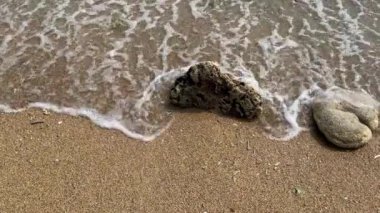 Sahildeki küçük dalgaların 4K videosu, kıyıdaki küçük dalgalar. Sakin ve sığ sularda hafif dalgalar dans etti. Malang Endonezya 'daki Kondang Merak Sahili