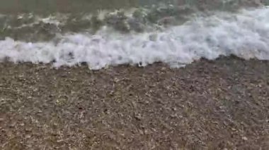 Sahildeki küçük dalgaların 4K videosu, kıyıdaki küçük dalgalar. Sakin ve sığ sularda hafif dalgalar dans etti. Malang Endonezya 'daki Kondang Merak Sahili