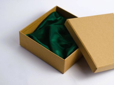 A minimalist opened cardboard gift box with green cloth inside for elegant craft and DIY product photography base, isolated on a pristine white background, copy space clipart