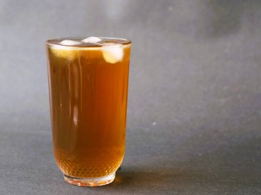 Kristal berrak bardakta zarif bir şekilde servis edilen ferahlatıcı bir bardak buzlu çay. Buzlu çayın kehribar rengi bardağın berraklığıyla güzel bir tezat oluşturuyor. Klasik bir buzlu çay, zamansız bir bardakta servis edilir, rahatlatıcı..