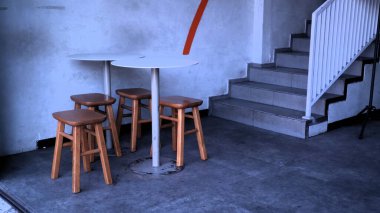 Sıcak, ahşap bir masa ve doğanın ortasına kurulmuş sandalyeler sakin bir açık hava inzivası sunuyor. Kırsal bir ahşap oturma alanı açık havada rahatlamak için bir minimalist sağlar. Büyüleyici ahşap bir teras seti rahat, davetkar bir açık kafe atmosferi yaratır..