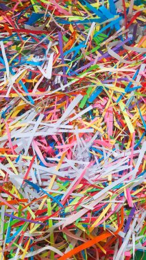 Çok renkli kağıt parçalarının soyut bir kompozisyonu sanatsal ve kutlama temalarına uygun görsel olarak canlandırıcı bir arka plan oluşturur. Renkli kağıt kırıntıları için canlı bir hava manzarası, sanat için eğlenceli bir zemin ve şenlik vesilesi..