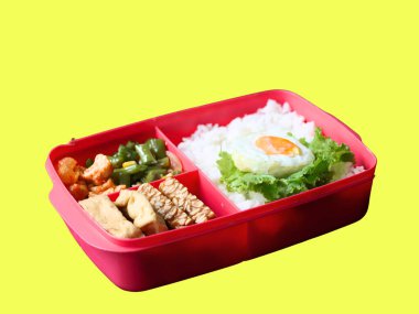 A balanced, healthy meal of rice, egg, stir-fried vegetables, and tofu-tempeh, in a lunchbox, suits busy students and office workers. A free lunch program by Prabowo in Indonesia served in a lunchbox. clipart