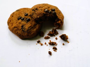 Parçalanmış çikolatalı kurabiye, yakınlarda kırıntılar var, izole edilmiş beyaz arka plana karşı seçici bir odak noktasında. Detaylı bir yemek fotoğrafı. Boşluğu kopyala