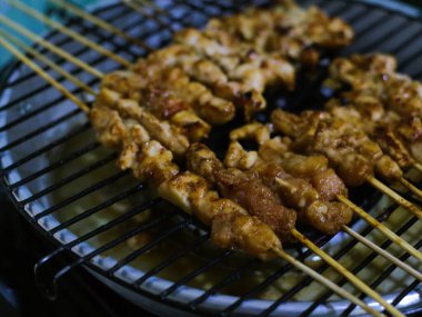 Sate ayam, ızgara tavuk satay, klasik bir Endonezya yemeği, közün üzerinde pişirilmiş tavuk, zengin bir fıstık sosu ve otantik Endonezya tadı için alevli sambal ile servis edilir.. 