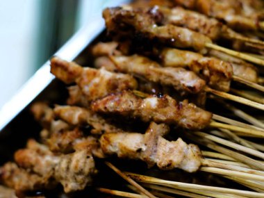 Sate ayam, ızgara tavuk satay, klasik bir Endonezya yemeği, közün üzerinde pişirilmiş tavuk, zengin bir fıstık sosu ve otantik Endonezya tadı için alevli sambal ile servis edilir.. 