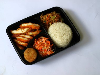 Katsu tavuğu, pilav, şehriye, patates püresi, sebze salatası ve börek, izole edilmiş beyaz bento kutusunda servis edilir, kopyalama alanı. Öğrenciler için uygun ve yoğun bir öğle yemeği. Besleyici gıdaları dengelemek. 