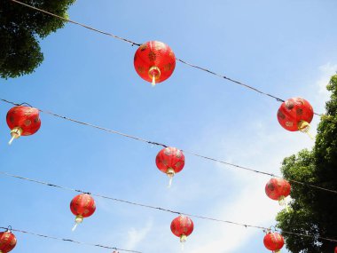 Çin Yeni Yıl kutlamaları sırasında sergilenen mavi gökyüzü arka planına sahip Çin fenerlerinin alt sıra görüntüsü.
