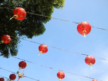 Çin Yeni Yıl kutlamaları sırasında sergilenen mavi gökyüzü arka planına sahip Çin fenerlerinin alt sıra görüntüsü.