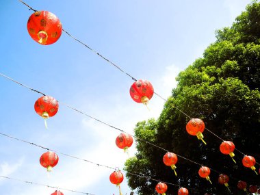 Çin Yeni Yıl kutlamaları sırasında sergilenen mavi gökyüzü arka planına sahip Çin fenerlerinin alt sıra görüntüsü.