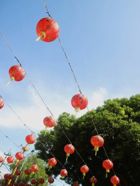 Çin Yeni Yıl kutlamaları sırasında sergilenen mavi gökyüzü arka planına sahip Çin fenerlerinin alt sıra görüntüsü.