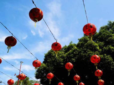 Çin Yeni Yıl kutlamaları sırasında sergilenen mavi gökyüzü arka planına sahip Çin fenerlerinin alt sıra görüntüsü.