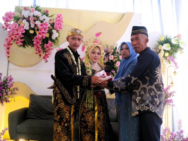 Erkek ve kadın aşığı çift, damat ve gelin geleneksel siyah elbiseli Endonezya Java düğün geleneği