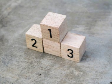 Üzerinde 1, 2 ve 3 rakamları yazılı tahta küplerin desenli gri arkaplanı var.