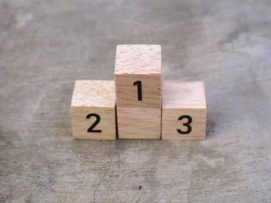 Üzerinde 1, 2 ve 3 rakamları yazılı tahta küplerin desenli gri arkaplanı var.