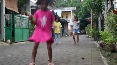 Asyalı Endonezyalı çocuklar, geleneksel Endonezya oyunu olan cengkleng veya Engklek oynamak için bir araya geldiler, cep telefonu aktivitesi yok, çocuklar için kentsel özgürlük olmayan neşeli yaşam tarzı