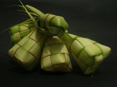 Siyah zemin üzerinde ketupat veya Kupat (Rice Dumpling veya olgun elmas). Endonezya 'dan ketupat, bayram bayramı sırasında pilav pişirmek için taze hindistan cevizi yapraklarından yapılan doğal pirinç kabı. Boşluğu kopyala