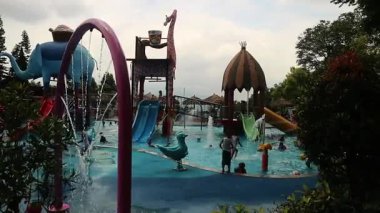 Çocuklar su parkına su sıçratıyor çocuklar Jatim Park 2 Malang East Java 'daki su parkında eğleniyor.