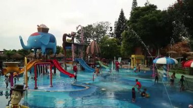Çocuklar su parkına su sıçratıyor çocuklar Jatim Park 2 Malang East Java 'daki su parkında eğleniyor.