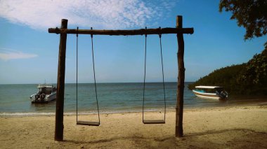 Ahşap salıncak ve mavi deniz arka planı, sağlık, yaşam tarzı, rahatlama, taze içecekler, dondurulmuş tatlılar ve eğlence gibi ürünler için uygun.