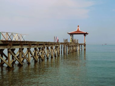 Pantai Pasir Putih Situbondo Endonezya 'da ahşap iskelede güzel bir gün doğumu manzarası, turizm gezisi merkezi.