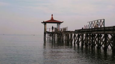 Pantai Pasir Putih Situbondo Endonezya 'da ahşap iskelede güzel bir gün doğumu manzarası, turizm gezisi merkezi.