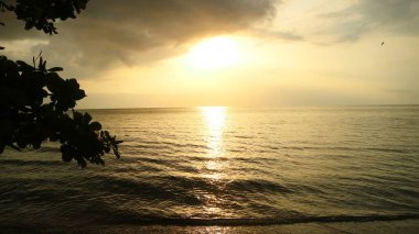 Tropiklerdeki lüks bir plajda panoramik günbatımı manzarası sakin okyanusun üzerinde sakin bir gün batımı.