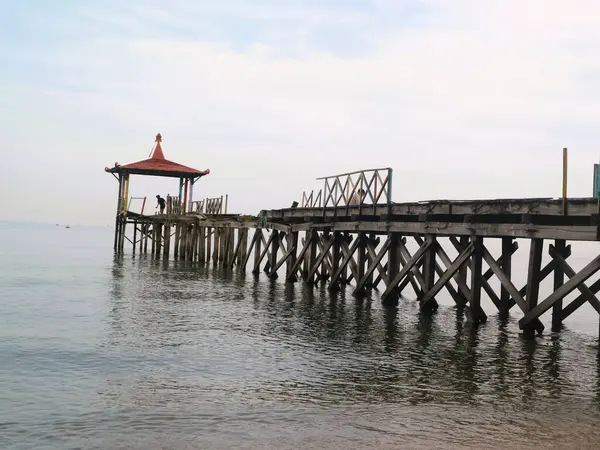 Pantai Pasir Putih Situbondo Endonezya 'da ahşap iskelede güzel bir gün doğumu manzarası, turizm gezisi merkezi.