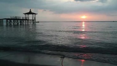 Endonezya, Pantai Pasir Putih Situbondo 'daki ahşap iskeleli güzel gün batımı manzarası. Doğa fotoğrafı kompozisyonu. Uzun Pozlandırma. 