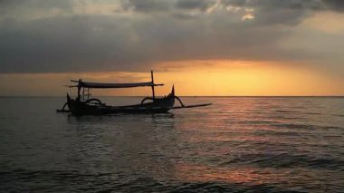 Tropik sahilde günbatımında balıkçı teknesi Pasir Putih, Endonezya Situbondo sahilinde.