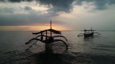 Tropik sahilde günbatımında balıkçı teknesi Pasir Putih, Endonezya Situbondo sahilinde.