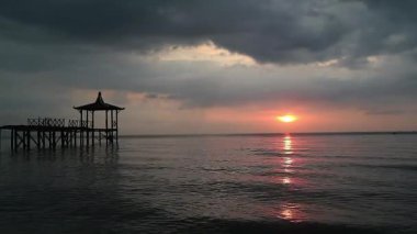 Tropiklerdeki lüks bir plajda panoramik günbatımı manzarası sakin okyanusta sakin bir gün batımı rahatlamak için mükemmel romantik bir arka plan.