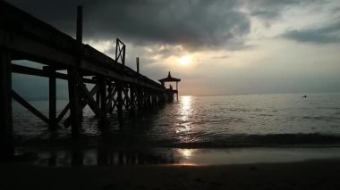 Endonezya, Pantai Pasir Putih Situbondo 'daki ahşap iskeleli güzel gün batımı manzarası. Doğa fotoğrafı kompozisyonu. Uzun Pozlandırma.
