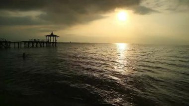 Tropiklerdeki lüks bir plajda panoramik günbatımı manzarası sakin okyanusta sakin bir gün batımı, Pasir Putih plajı Situbondo Endonezya