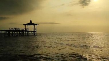 Tropiklerdeki lüks bir plajda panoramik günbatımı manzarası sakin okyanusta sakin bir gün batımı, Pasir Putih plajı Situbondo Endonezya