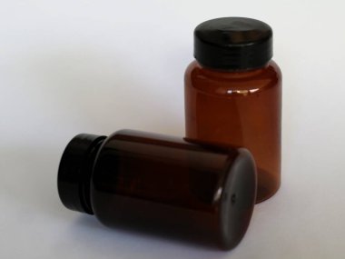 Siyah şapkalı kahverengi cam şişe, izole edilmiş beyaz, seçici odak