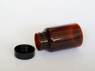 Siyah şapkalı kahverengi cam şişe, izole edilmiş beyaz, seçici odak