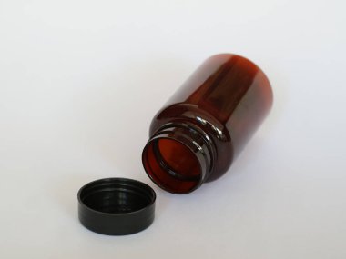 Siyah şapkalı kahverengi cam şişe, izole edilmiş beyaz, seçici odak