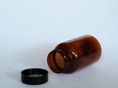 Siyah şapkalı kahverengi cam şişe, izole edilmiş beyaz, seçici odak