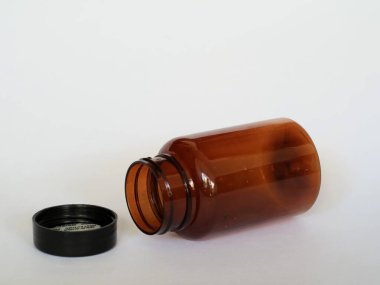 Siyah şapkalı kahverengi cam şişe, izole edilmiş beyaz, seçici odak