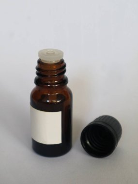 Brown glass bottle for medicine with a blank white label and a black cap, isolated white