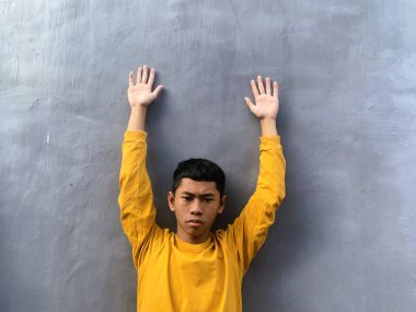 Sarı tişörtlü Güneydoğu Asyalı bir gencin özgün portresi. Neşeli ve umut dolu ifadesi egzotik ve enerjik bir enerji yakalıyor.