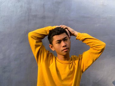 Neşeli bir Güneydoğu Asyalı adam, komik bir ifadeyle, kahkaha ve mutluluğun ruh sağlığı için güçlü bir ilaç, komik bir yüz olduğu fikrini somutlaştırıyor.